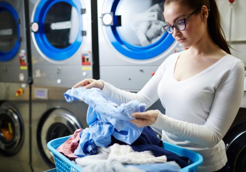 Woman looking at dirty shirt in laundry